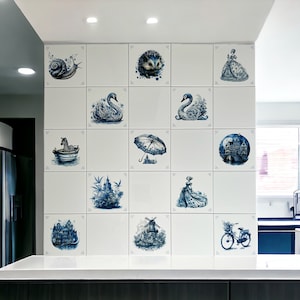 May include: A white tiled wall with blue and white Delftware tiles featuring various designs, including a snail, a hedgehog, swans, a zebra, an umbrella, a city scene, a castle, a windmill, a woman in a dress, and a bicycle.