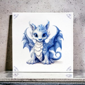 Puede incluir: Un dragón azul y blanco con un remolino en la cabeza y las alas extendidas. El dragón está sentado sobre un fondo blanco.