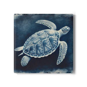 May include: Square canvas art depicting a detailed illustration of a sea turtle in white and blue hues. The turtle is shown swimming, with its flippers outstretched. The background is a dark blue, providing a contrast that accentuates the turtle.