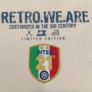 Può includere: Borsa tote color crema con la scritta "RETRO.WE.ARE" e "CUSTOMIZED IN THE XXI CENTURY". Sulla borsa è cucita una toppa con il logo dell'Inter. La toppa è verde, bianca, rossa e dorata.