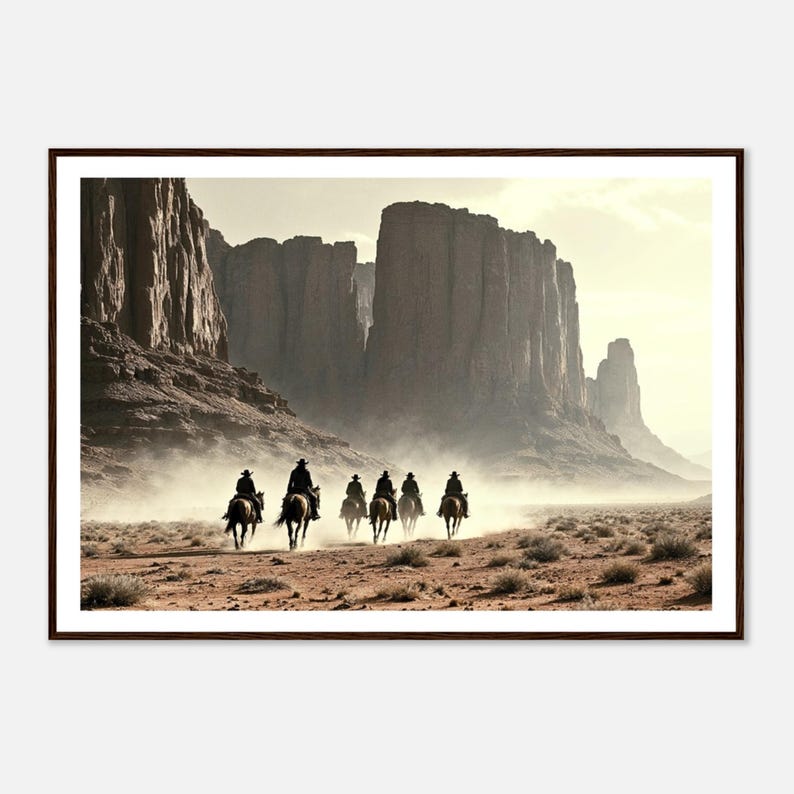 May include: A framed photograph of a group of six cowboys riding horses through a desert canyon. The cowboys are silhouetted against the bright light of the setting sun. The canyon walls are tall and rocky, and the desert floor is covered in sand and dust.