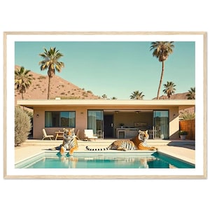 May include: A framed print featuring two tigers lounging by a swimming pool in front of a mid-century modern home. The scene is set against a backdrop of palm trees and a clear blue sky, creating a serene and exotic vibe.
