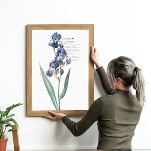 May include: A framed print with a watercolor illustration of a purple iris flower. The print includes the name "Jordan" and the word "Courage" with a definition.