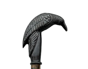 May include: A black crow-shaped walking stick handle with a wooden shaft.