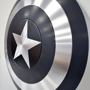 May include: A black and silver Captain America shield with a five-pointed star in the center.
