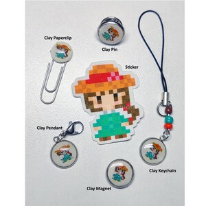 May include: A collection of handmade clay accessories featuring a pixelated character design. Includes a paperclip, pin, pendant, sticker, magnet, and keychain. The character wears a green dress and a brown hat. The accessories are on a white surface.