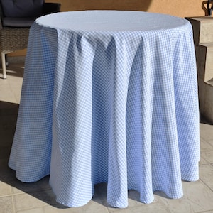 May include: A light blue gingham tablecloth with white squares. The tablecloth is draped over a round table.