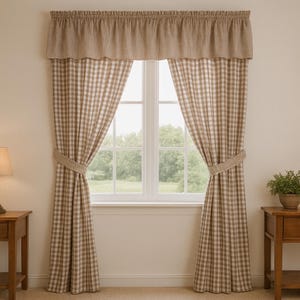 Puede incluir: Un juego de cortinas para ventana con un patrón de cuadros vichy en color tostado y blanco. El conjunto incluye dos paneles de largo hasta el suelo sujetos con alzapaños a juego y un volante fruncido en la parte superior.