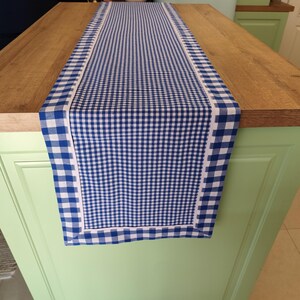 Peut inclure: Un chemin de table à carreaux bleus et blancs avec une bordure blanche. Le chemin de table est en tissu et a un motif vichy.