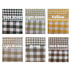 May include: A collection of fabric swatches in various colors, each featuring a gingham pattern. The swatches include dark green, light green, yellow, light brown, brown, and dark brown. Each swatch has the color name printed on it.