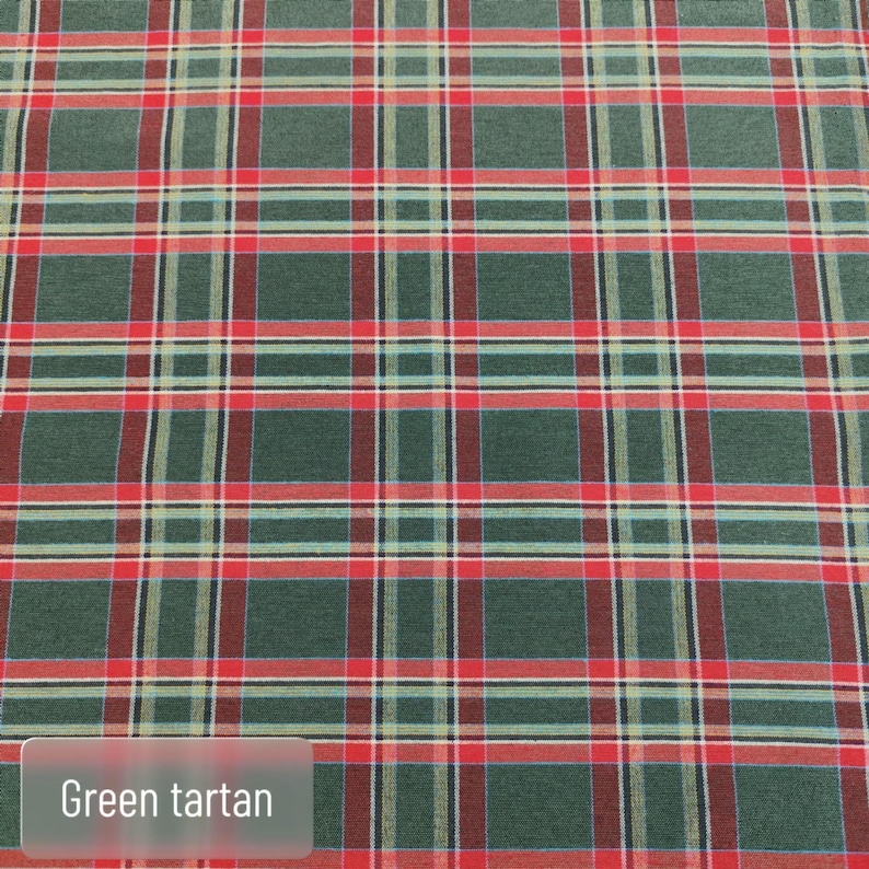 Pode incluir: Um tecido com um padr&atilde;o de tartan verde com linhas horizontais e verticais que se cruzam em vermelho, branco e preto. O t&ecirc;xtil apresenta um design xadrez repetitivo em toda a superf&iacute;cie, com o texto Green tartan vis&iacute;vel.