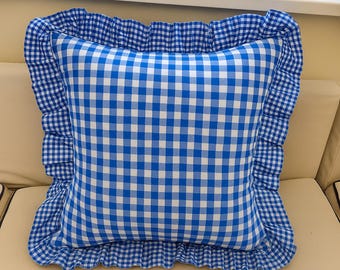 Op de afbeelding: Een vierkant sierkussen met een levendig blauw en wit vichy-ruitpatroon. Het kussen is afgewerkt met een geplooide, ruches rand gemaakt van dezelfde blauw-wit geblokte stof, wat zorgt voor een decoratieve rand rondom het kussen.