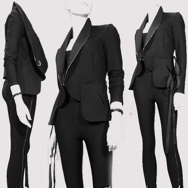 May include: Three mannequins display a black blazer with a contrasting lapel and a single pocket. The blazer is paired with matching black leggings. The outfits are accessorized with a black bracelet and a black ribbon detail.