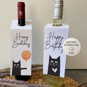 Könnte beinhalten: Zwei druckbare Weinflaschen-Geschenk-Etiketten mit schwarzen Katzenillustrationen. Eine Etikette zeigt eine Katze mit einem Herzen und dem Text "Happy Birthday". Die andere Etikette zeigt eine Katze, die einen Ballon hält, und den Text "Happy Birthday". Die Etiketten sind mit "Sofortiger Download PDF" gekennzeichnet.
