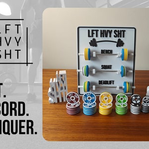 Può includere: Una lavagna bianca con il testo "LFT HVY SHT" e un grafico di bilanciere. La lavagna ha tre righe con le parole "BENCH", "SQUAT" e "DEADLIFT" e un set di piastre per pesi su ogni riga. Ci sono anche pile di piastre per pesi di diversi colori su una superficie di legno.