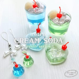 May include: A collection of retro-themed resin art pieces and drink charms. The image features two cream soda glasses with cherries, and heart-shaped resin pieces. The text "retro CREAM SODA resin series" is visible.