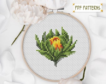 May include: A cross-stitch pattern of a yellow flower with green leaves in a wooden embroidery hoop. The hoop is on a white background with white flower petals.