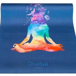 Puede incluir: Una esterilla de yoga azul con un dise&ntilde;o de acuarela de una persona en una postura de meditaci&oacute;n sentada. El dise&ntilde;o presenta un arco&iacute;ris de colores. El texto "Divasya Yoga" est&aacute; impreso en la esterilla.