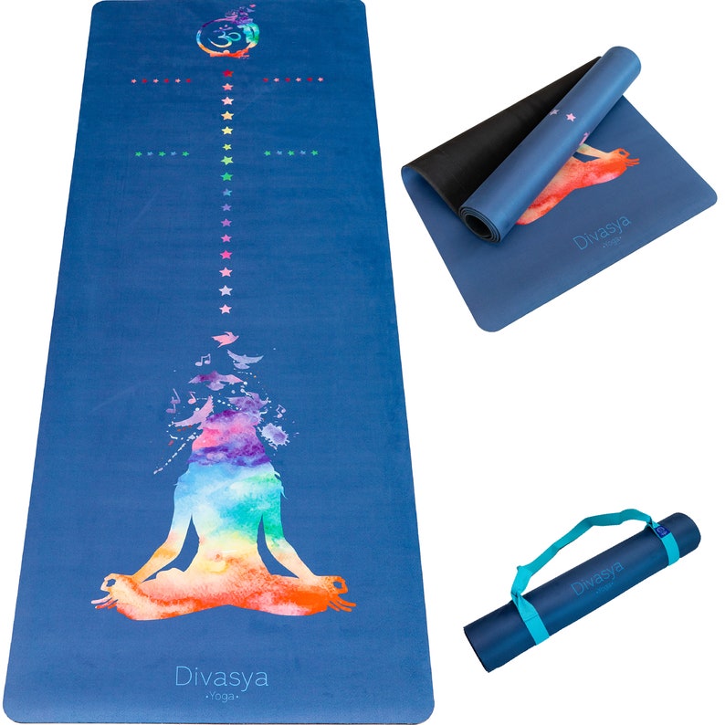 Puede incluir: Una esterilla de yoga azul con un dise&ntilde;o de acuarela colorido de una persona meditando. La esterilla tiene un patr&oacute;n de estrellas blancas y el texto "Divasya Yoga" impreso en ella. La esterilla est&aacute; enrollada y tiene una correa de transporte negra.