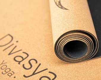 Puede incluir: Una esterilla de yoga de corcho enrollada con un diseño en blanco y negro y el texto "Divasya Yoga". La esterilla es marrón y tiene una textura de corcho natural.