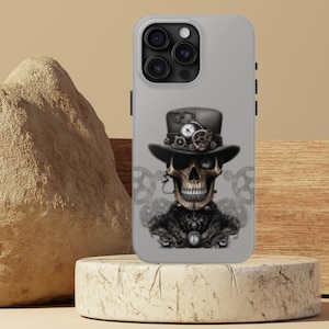 May include: A gray iPhone case with a steampunk skull design. The skull is wearing a black top hat with gears and a clock face. The background is a gray pattern of gears.