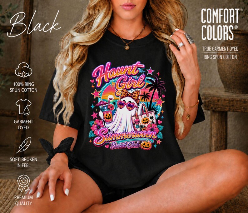 Puede incluir: Una camiseta negra con un estampado gr&aacute;fico de un fantasma con gafas de sol en forma de coraz&oacute;n y un lazo de leopardo. El texto dice Haunt Girl Summerween Social Club. El dise&ntilde;o incluye palmeras, flores de hibisco y calabazas.