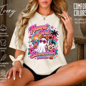 Puede incluir: Una camiseta color marfil con un estampado gr&aacute;fico que incluye el texto Haunt Girl Summerween Social Club. El dise&ntilde;o muestra un fantasma con gafas de sol en forma de coraz&oacute;n y un lazo de leopardo, palmeras, flores de hibisco y calabazas.