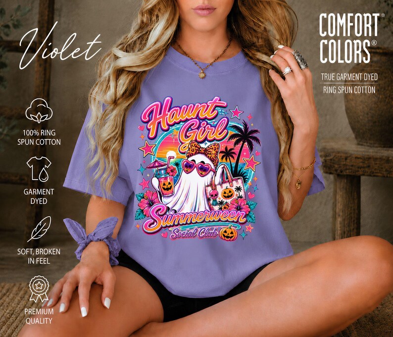 Puede incluir: Una camiseta violeta con un estampado gr&aacute;fico de un fantasma con gafas de sol en forma de coraz&oacute;n y un lazo de leopardo, sosteniendo una bebida y un bolso. El texto dice Haunt Girl Summerween Social Club, rodeado de palmeras y calabazas.