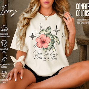 人生を一つずつ波に乗せて生きるインスピレーションTシャツ、禁酒生活ビーチシャツ、NA AA回復ギフト、ウミガメとハイビスカスのコンフォートカラー