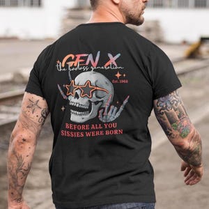 Può includere: T-shirt nero con un disegno di teschio con occhiali da sole a forma di stella. Il testo recita "GEN X the badass generation Est. 1968" e "BEFORE ALL YOU SISSIES WERE BORN."