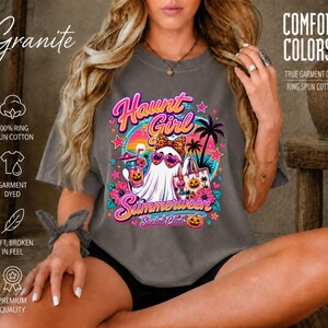 Puede incluir: Una camiseta de manga corta color granito con un estampado gr&aacute;fico de un fantasma con gafas de sol y un lazo de leopardo, sosteniendo una bebida y un bolso, con palmeras, calabazas y el texto Haunt Girl Summerween Social Club.