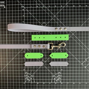 May include: A set of light gray and lime green dog leash accessories. The set includes a leash, a collar, two short straps, and a metal clasp.