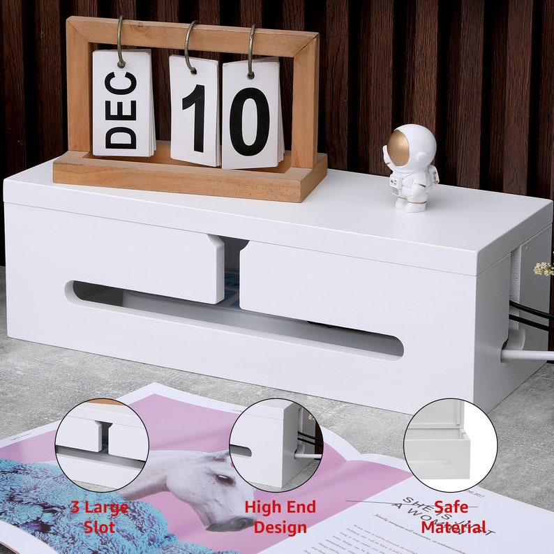 May include: A white cable management box with a wooden calendar displaying "DEC 10" and a small astronaut figurine. The box has slots for cords and the text "3 Large Slot", "High End Design", and "Safe Material".