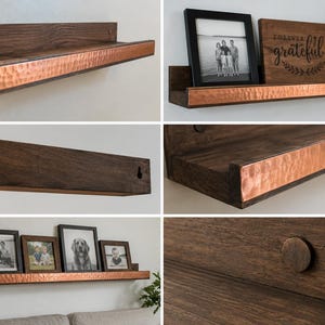 May include: A dark brown wooden wall shelf featuring a front edge accented with a hammered copper metal strip. The shelf includes a back panel with keyhole slots for mounting and a circular wooden plug detail on the side of the shelf structure.