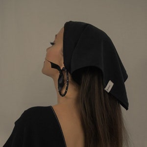 Girl wearing a black matte sustainable head scarf by Carmen Calburean.