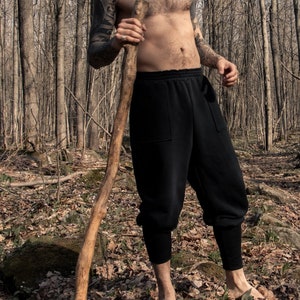 Man wearing black organic sweatpants with high rib cuffs by Carmen Calburean.