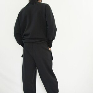 Man wearing black organic sweatpants with high rib cuffs by Carmen Calburean.