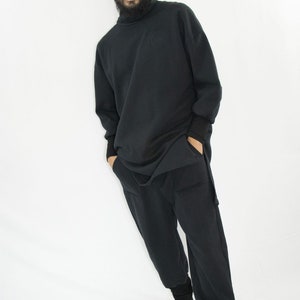 Man wearing black organic sweatpants with high rib cuffs by Carmen Calburean.