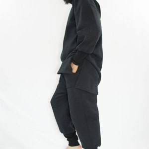 Man wearing black organic sweatpants with high rib cuffs by Carmen Calburean.