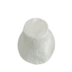 White organic Bucket hat with large brim and moon embroidered on top by Carmen Calburean.