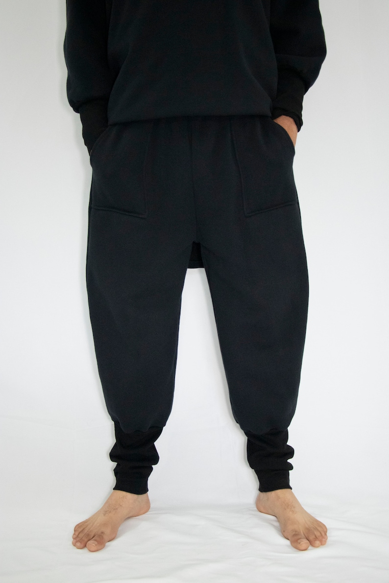 Man wearing black organic sweatpants with high rib cuffs by Carmen Calburean.