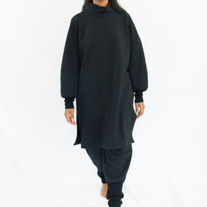 Woman wearing black organic sweatpants with high rib cuffs by Carmen Calburean.
