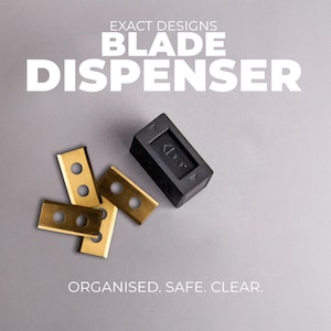 May include: A black blade dispenser with three gold-colored blades. The dispenser is rectangular and has a small arrow symbol. The text "EXACT DESIGNS BLADE DISPENSER" is at the top, with "ORGANISED. SAFE. CLEAR." at the bottom.