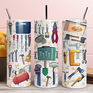May include: Three stainless steel tumblers with a white background and colourful illustrations of tools. The tumblers feature a variety of tools, including wrenches, hammers, screwdrivers, pliers, and saws.