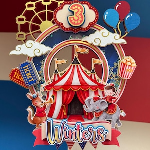 May include: A multi-layered cake topper featuring a red and white striped circus tent, a Ferris wheel, balloons, popcorn, and tickets. The topper includes the number 3 at the top and the name Winters in cursive script at the bottom, with a kangaroo and elephant.