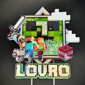 Può includere: Un topper per torta multistrato con i personaggi di Minecraft Steve e Alex, un lupo, una spada, un piccone e un blocco TNT. Il design include uno sfondo verde pixelato, il numero 7 e il nome LOURO in un carattere a blocchi pixelato.