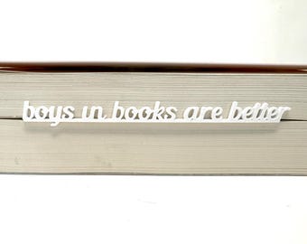 Marcapáginas con el diseño "Los chicos en los libros son mejores" (disponible en varios colores).