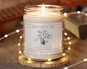 May include: A white candle with a brown label that reads "SEPTEMBER 24, 1984 LIBRA  Blushbell  Your desire for balance and peace resonates with the intangible beauty and scent of Blushbell.  Lovely candle 9 oz Soy Wax"