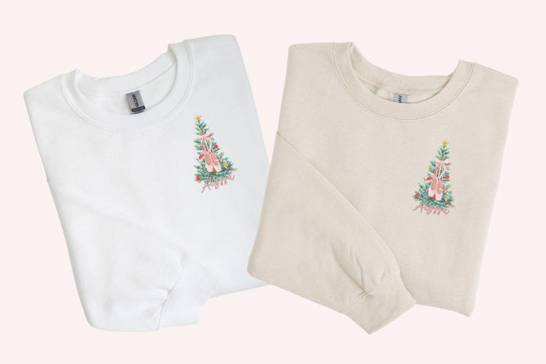 May include: Two long-sleeved sweatshirts with a Christmas tree design featuring ballet shoes and the name "Anya". One sweatshirt is white and the other is beige.