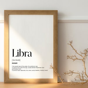May include: A framed print with the word "Libra" in black text, followed by the phonetic pronunciation in brackets, "[lee-bruh]". The word "noun" is below the pronunciation, followed by a definition of the astrological sign Libra.